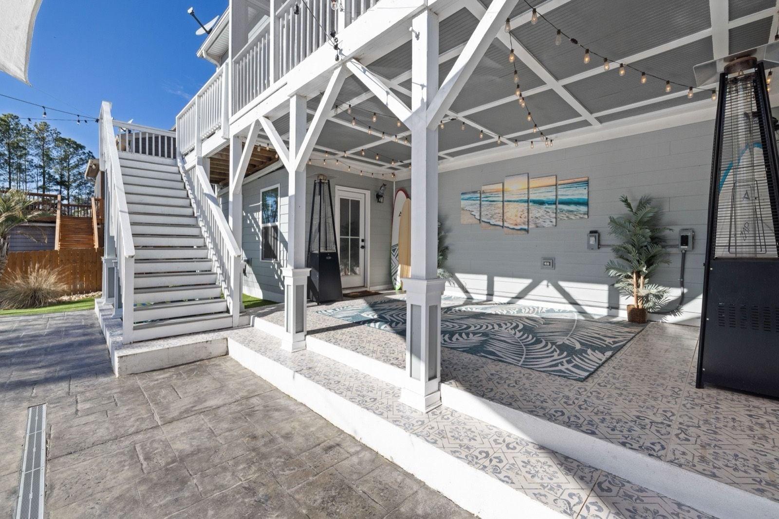 White painted posts, railings and stairs beside a gray painted ceiling and siding on a covered patio